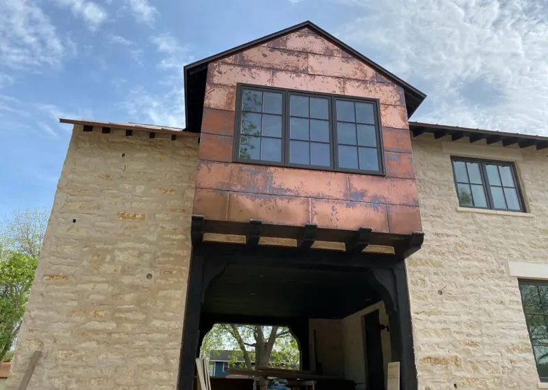 Copper metal panel facade on a stone building for Roof Repair in Clute