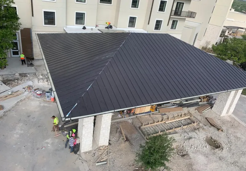 Metal roofing installation team working on a commercial building in Clute